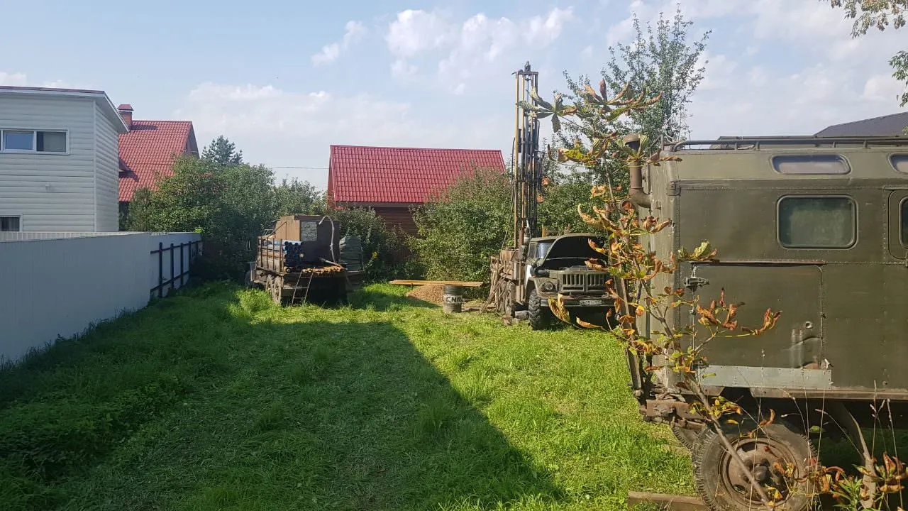 Военная техника стоит во дворе между загородными домами.